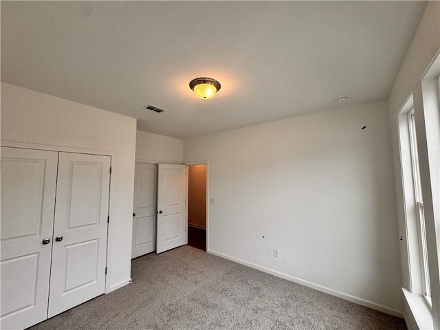 unfurnished bedroom featuring carpet, visible vents, and baseboards