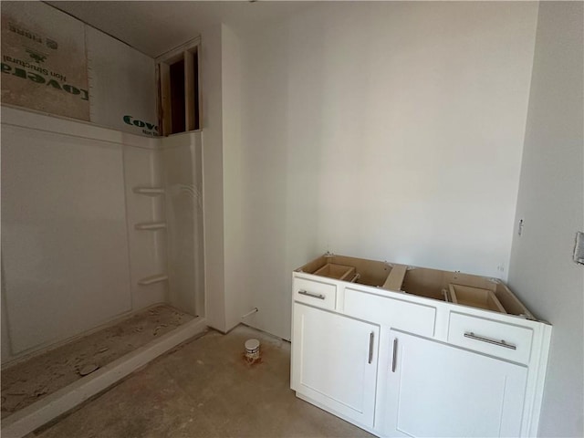 bathroom with concrete flooring and walk in shower