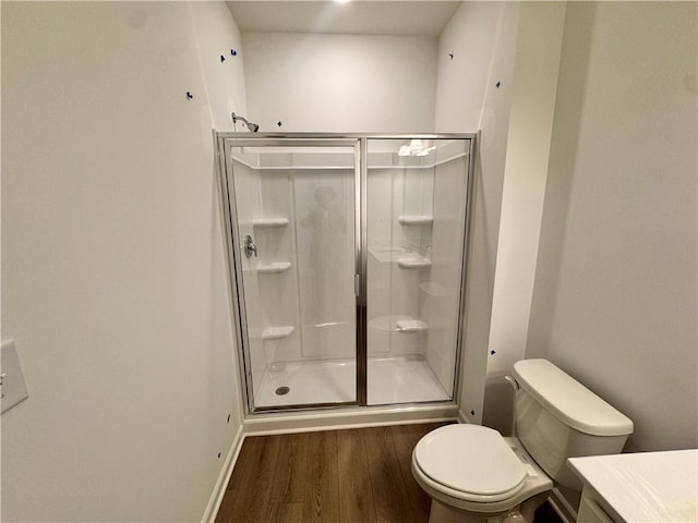 bathroom with vanity, a shower stall, toilet, and wood finished floors