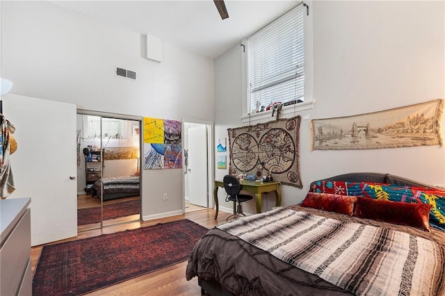 1031 State St NW Unit 106, Atlanta, GA 30318 - bedroom featuring wood finished floors, a high ceiling, ceiling fan, and a closet