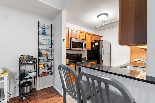 1031 State St NW Unit 106, Atlanta, GA 30318 - kitchen with appliances with stainless steel finishes, a sink, dark stone counters, wood finished floors, and baseboards