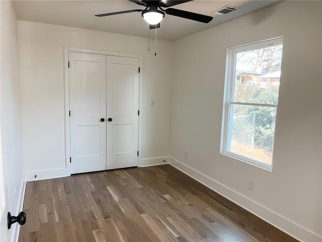 unfurnished bedroom with wood-type flooring, ceiling fan, and a closet