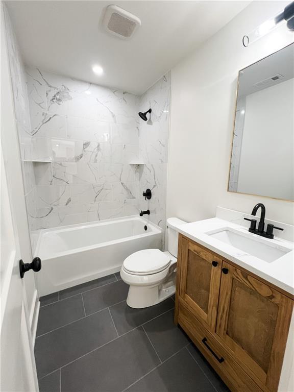 full bathroom with vanity, toilet, tiled shower / bath combo, and tile patterned flooring