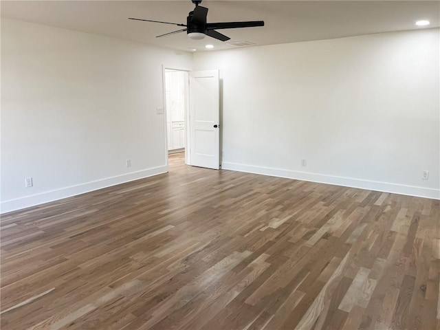 empty room with ceiling fan and dark hardwood / wood-style flooring