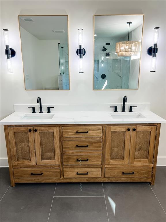 bathroom featuring walk in shower, vanity, and tile patterned flooring