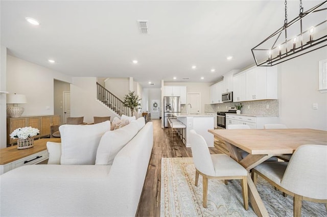 dining space featuring stairway, recessed lighting, visible vents, and light wood finished floors