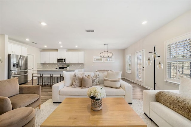 living area featuring light wood finished floors, visible vents, and recessed lighting