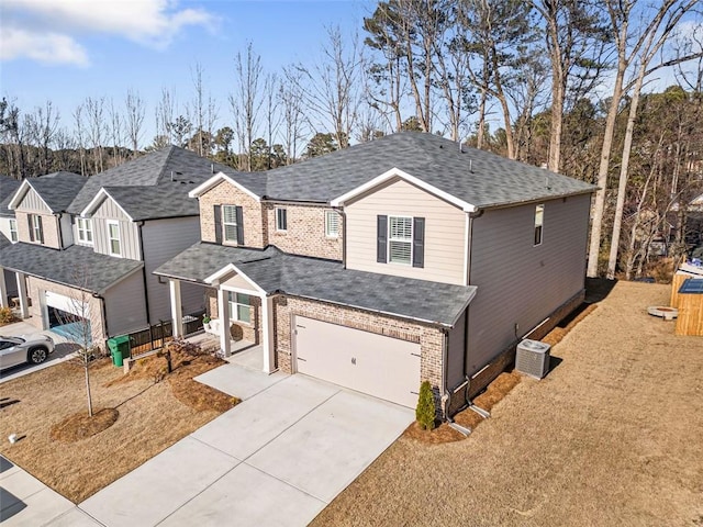 traditional home featuring central air condition unit, brick siding, roof with shingles, and concrete driveway