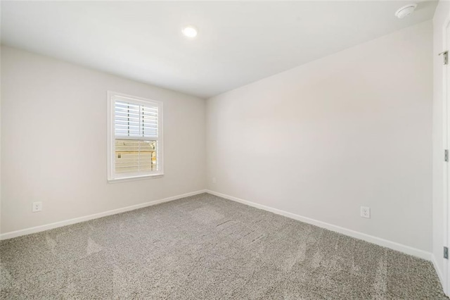 empty room featuring baseboards and carpet flooring