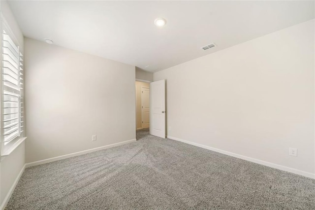 carpeted empty room with baseboards and visible vents