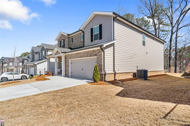 view of home's exterior with brick siding, a residential view, central air condition unit, concrete driveway, and a garage