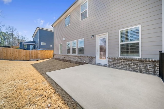 back of property featuring brick siding, a patio area, and fence