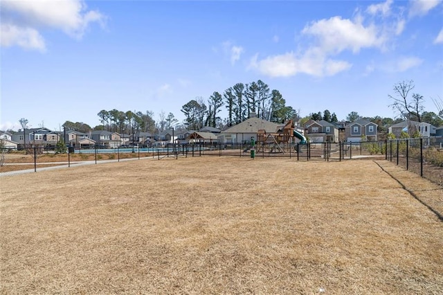 view of yard with a residential view, playground community, and fence