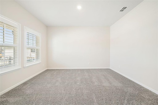 unfurnished room featuring baseboards, visible vents, and carpet floors