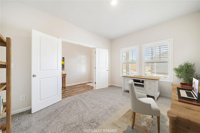 carpeted office space featuring baseboards