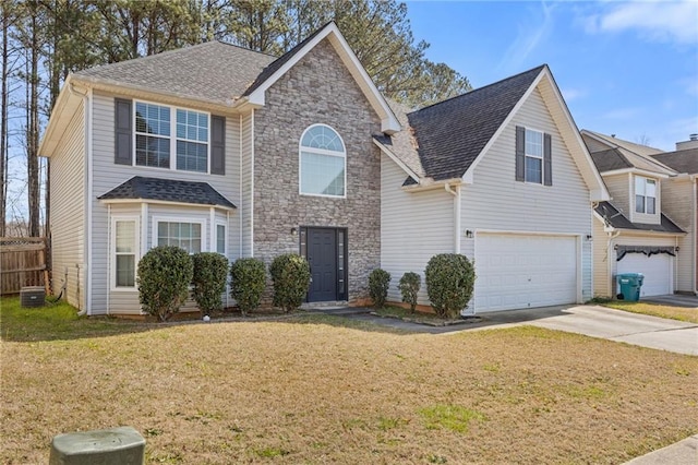 traditional home featuring an attached garage, fence, driveway, roof with shingles, and a front yard