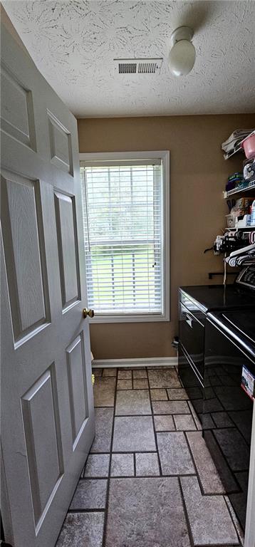 washroom featuring a textured ceiling and washer and dryer