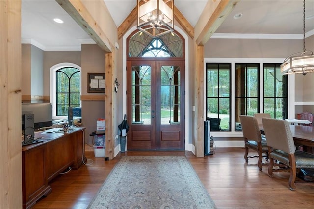 foyer featuring hardwood / wood-style floors, a healthy amount of sunlight, french doors, and a notable chandelier