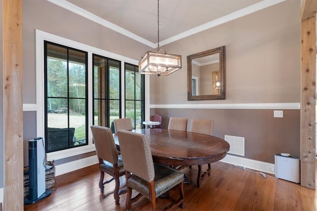 dining area with wood-type flooring and crown molding