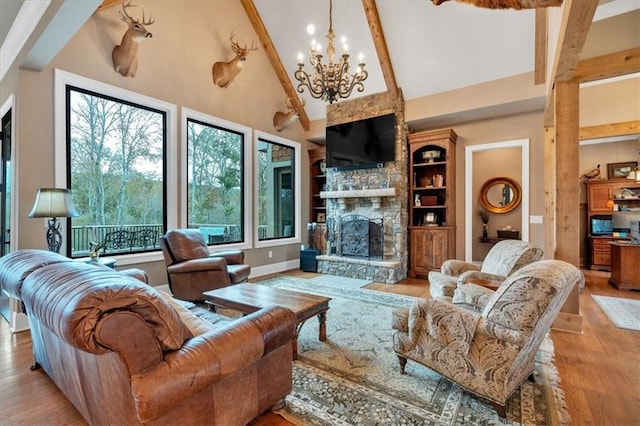 living room with a stone fireplace, an inviting chandelier, high vaulted ceiling, beamed ceiling, and light hardwood / wood-style flooring