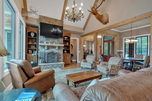 living room featuring a stone fireplace, hardwood / wood-style floors, a notable chandelier, high vaulted ceiling, and crown molding