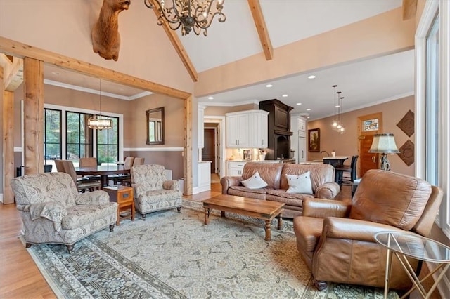 living room with beamed ceiling, high vaulted ceiling, a chandelier, light hardwood / wood-style flooring, and crown molding