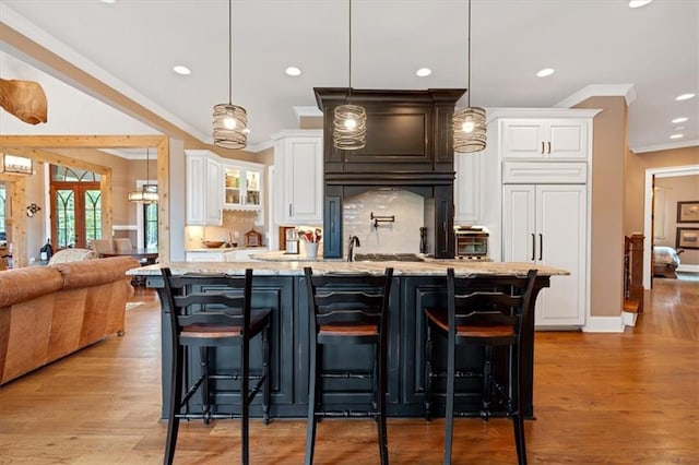 kitchen featuring a wealth of natural light, a breakfast bar, and white cabinets