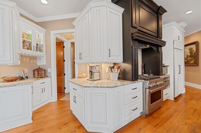 kitchen featuring white cabinets, light hardwood / wood-style floors, stainless steel stove, and crown molding