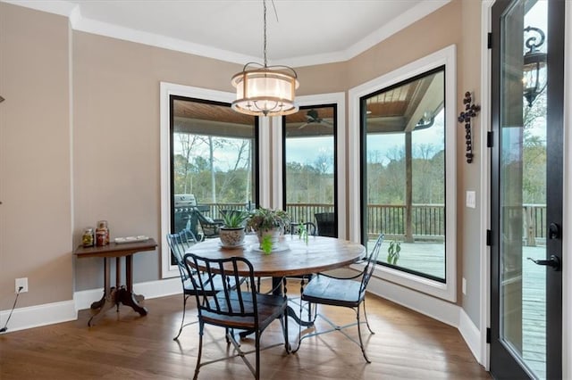 dining area featuring dark hardwood / wood-style flooring, a notable chandelier, and crown molding