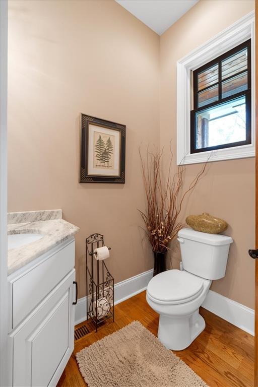 bathroom featuring toilet, vanity, and hardwood / wood-style floors