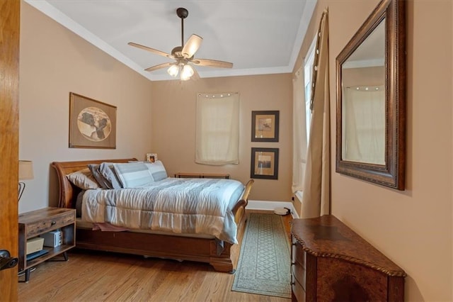 bedroom featuring ceiling fan, light hardwood / wood-style flooring, and crown molding