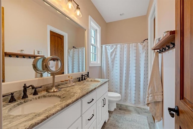 bathroom with toilet, vanity, and tile patterned flooring