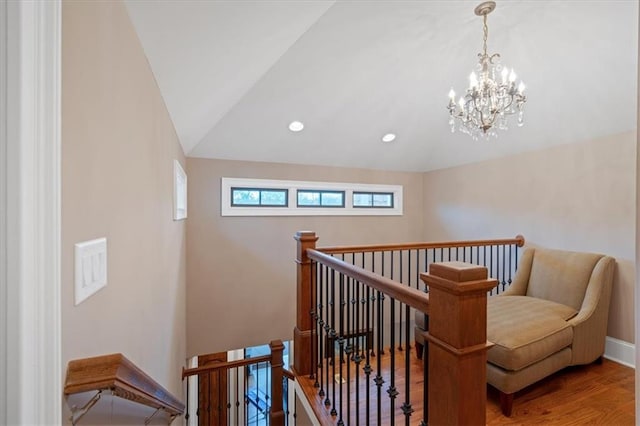 staircase featuring wood-type flooring, lofted ceiling, and a notable chandelier