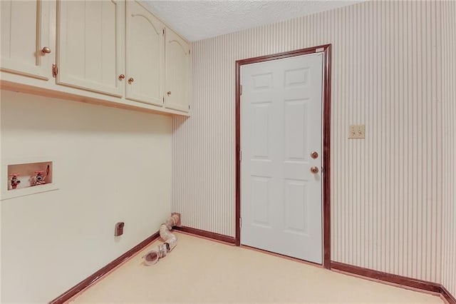 clothes washing area featuring a textured ceiling, cabinet space, baseboards, hookup for a washing machine, and wallpapered walls