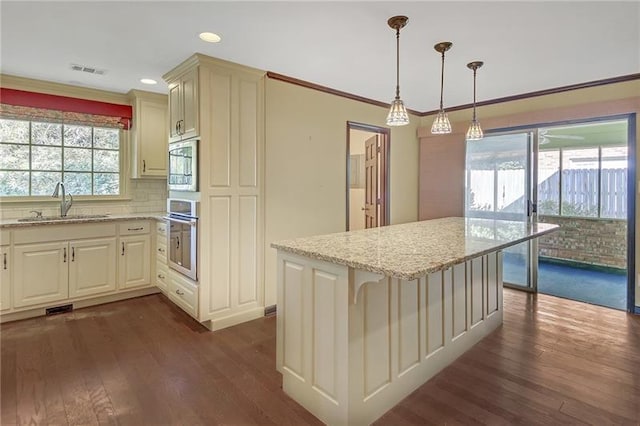 kitchen with oven, light stone counters, a sink, dark wood-type flooring, and visible vents
