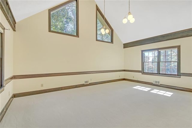 spare room featuring carpet floors, baseboards, and high vaulted ceiling
