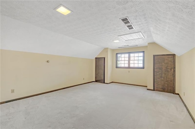 additional living space featuring visible vents, baseboards, vaulted ceiling, and light carpet