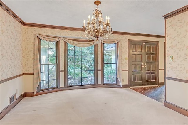 unfurnished dining area featuring an inviting chandelier, ornamental molding, baseboards, wallpapered walls, and carpet flooring