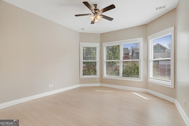 empty room with a ceiling fan, baseboards, visible vents, and light wood-type flooring