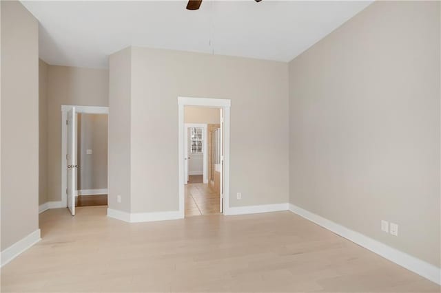 empty room with baseboards, light wood-style floors, and ceiling fan