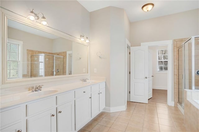 full bath with double vanity, tile patterned floors, a stall shower, and a sink