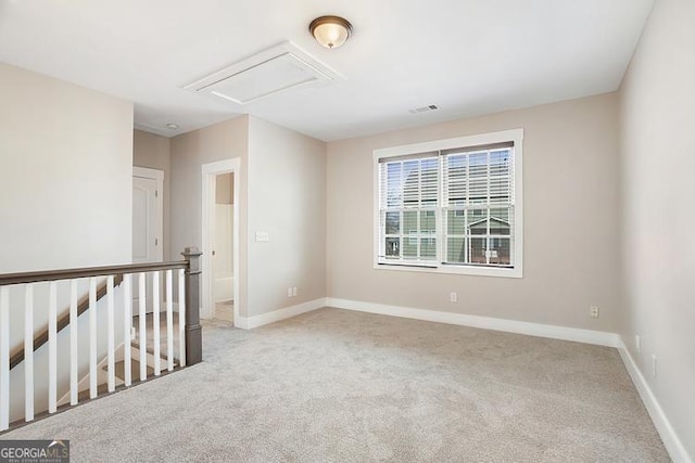 empty room with visible vents, light colored carpet, and baseboards