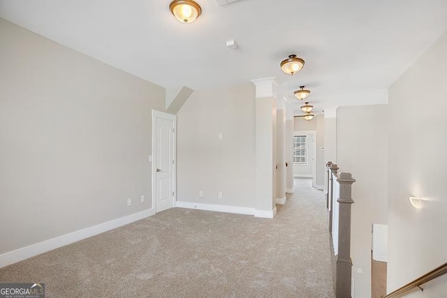 interior space with baseboards, carpet floors, and an upstairs landing