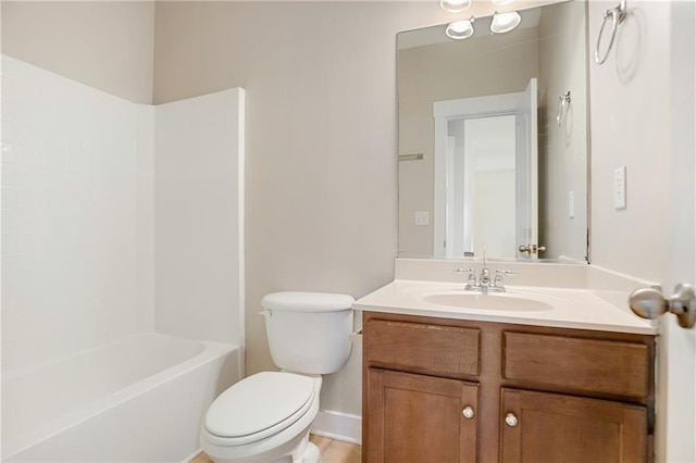 bathroom featuring toilet, vanity, washtub / shower combination, and baseboards