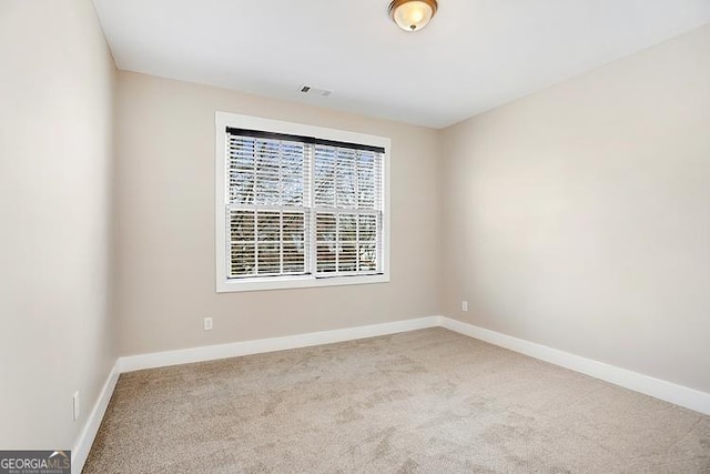 carpeted spare room featuring baseboards