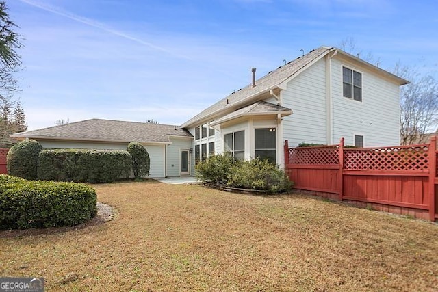 back of property with a patio area, a lawn, and fence