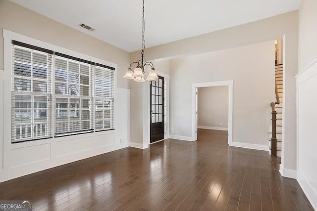 unfurnished dining area with visible vents, a notable chandelier, dark wood-style flooring, and stairway