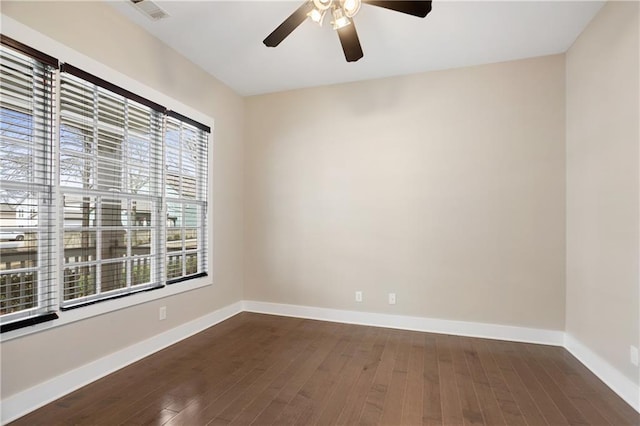 spare room featuring baseboards, plenty of natural light, dark wood-style floors, and ceiling fan