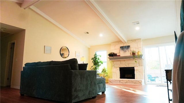 living room featuring beamed ceiling, a healthy amount of sunlight, and dark wood-type flooring