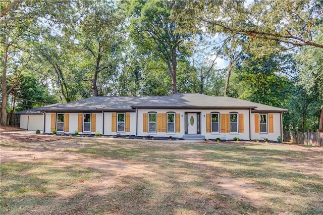 single story home featuring an attached garage, fence, and a front lawn